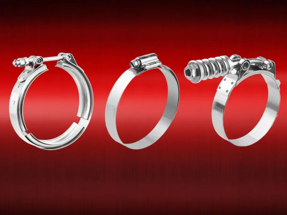 Stainless steel hose clamps installed on plumbing pipes, showing worm-drive, T-bolt, and V-band clamps used for secure, leak-proof plumbing connections.